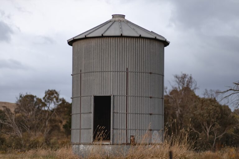 A large metal silo sitting in the middle of a field