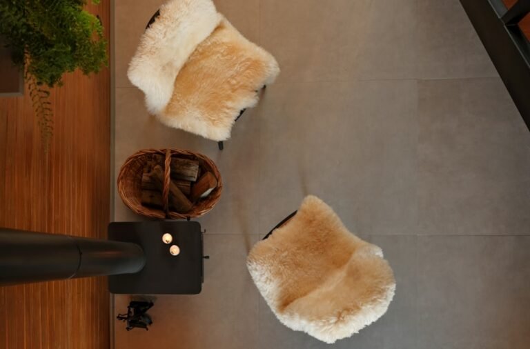 Two fluffy chairs and a basket of wood.