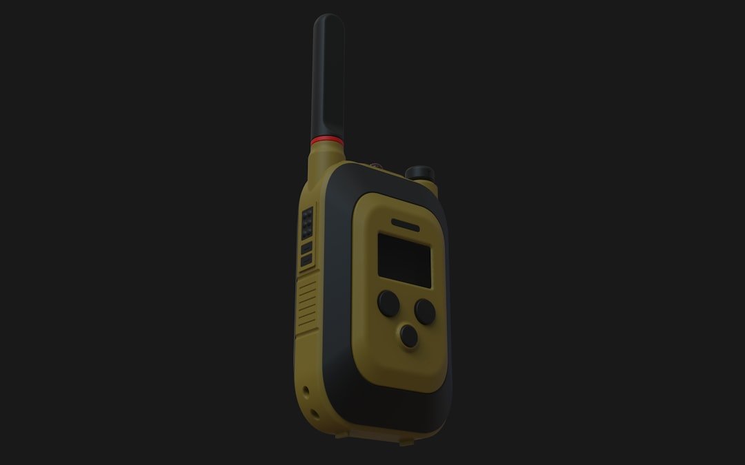 A yellow and black walkie-talkie on a dark background.
