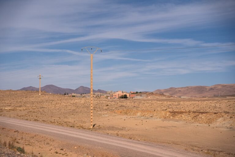 Desert landscape with distant buildings and mountains.