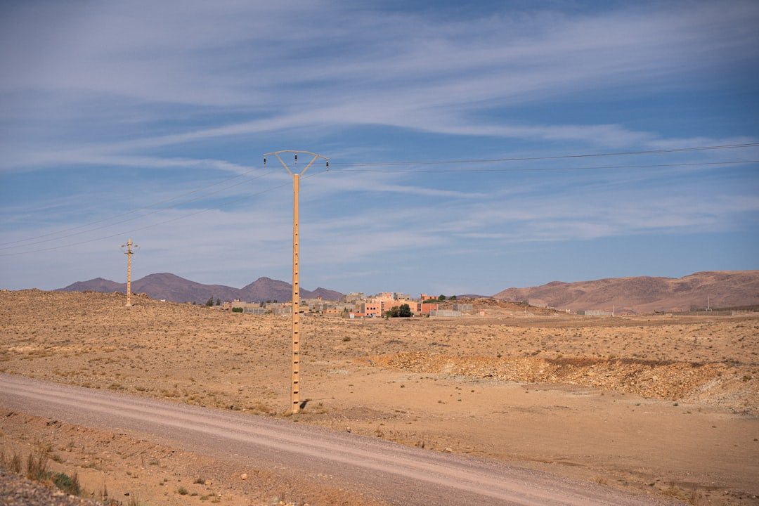 Desert landscape with distant buildings and mountains.