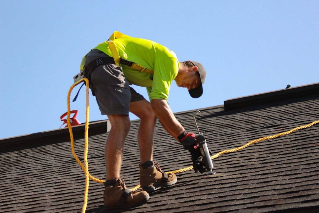 A man working on a roof with a power drill