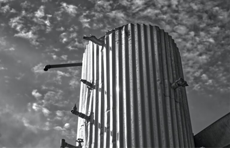 Corrugated metal silo against a cloudy sky