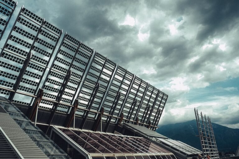 Modern building with large solar panels under cloudy sky