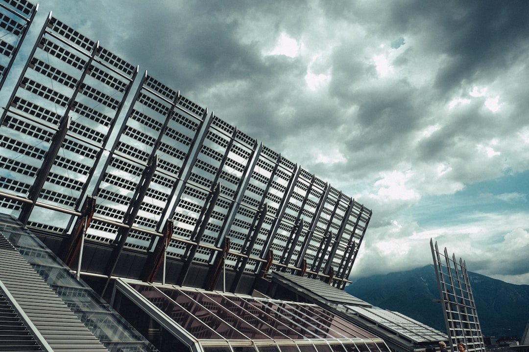Modern building with large solar panels under cloudy sky
