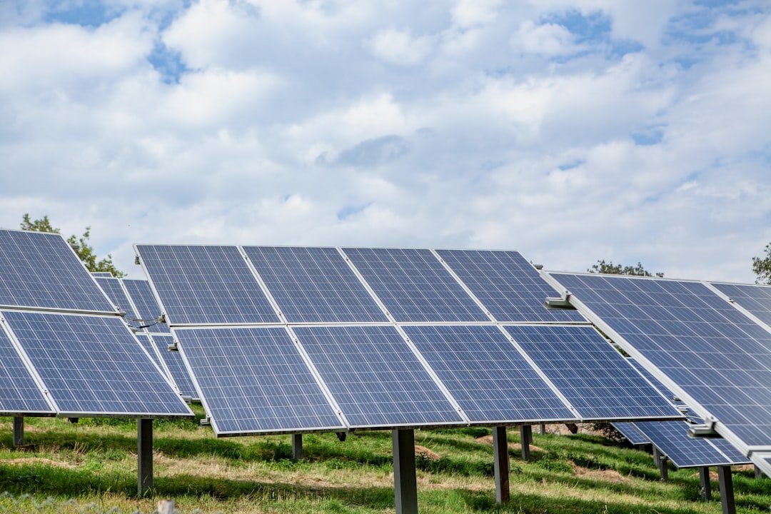 Solar panels in a field under a cloudy sky