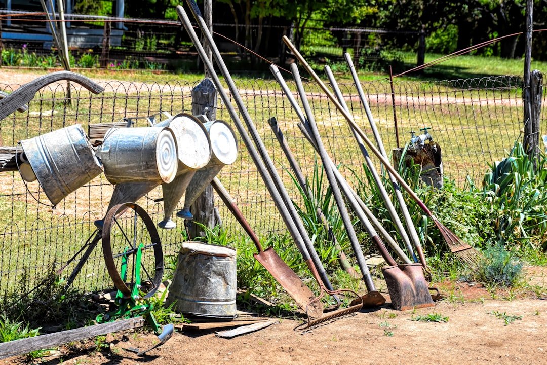 An old fashioned water pump sitting next to a fence