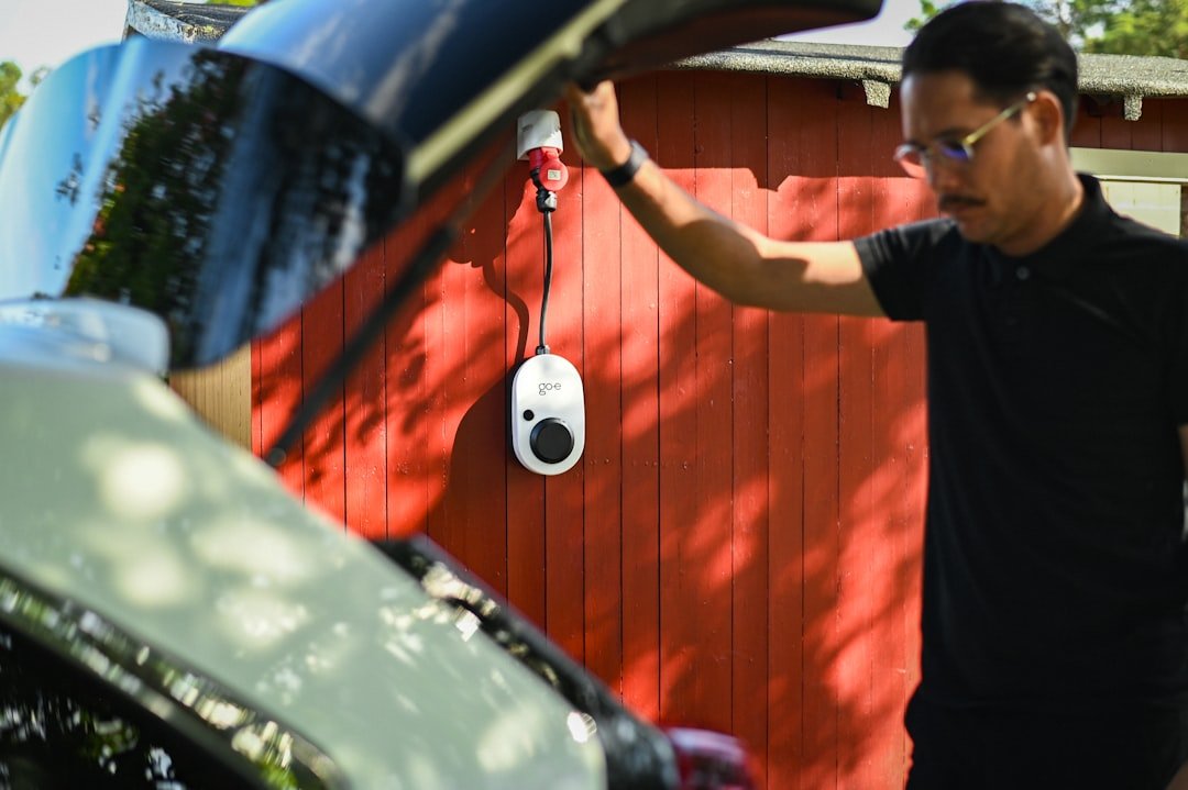 Man is about to charge an electric car.