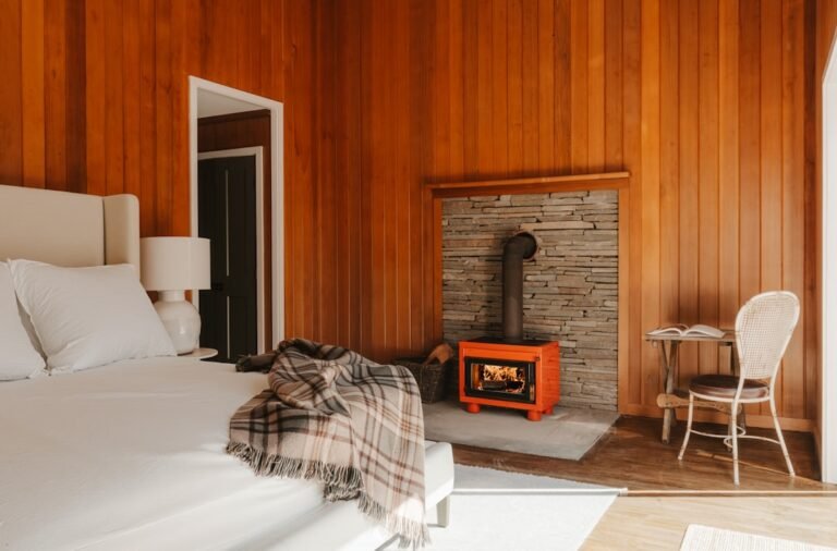 Cozy bedroom with wood paneling and a fireplace