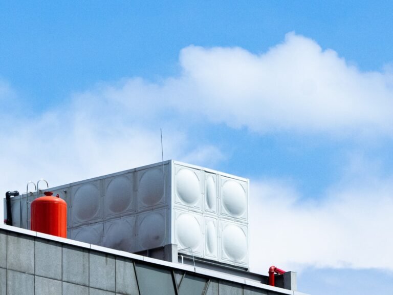 A tall building with a red and white object on top of it