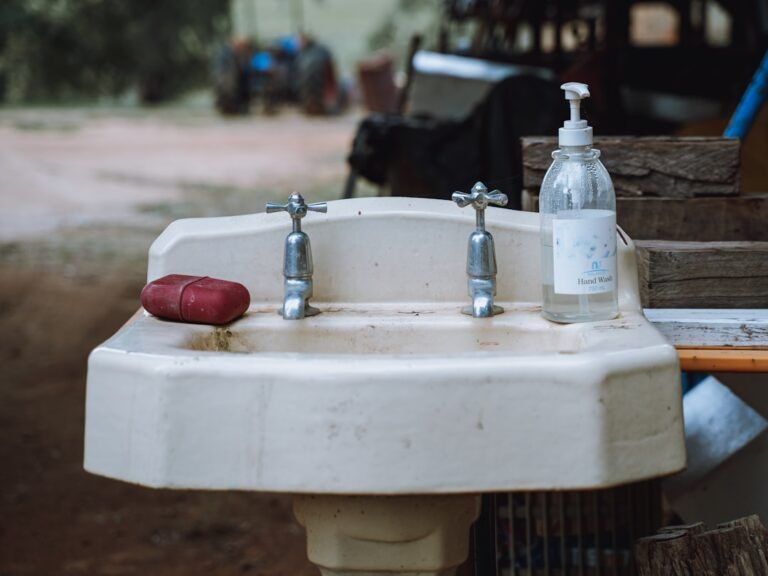 A white sink sitting next to a wooden table