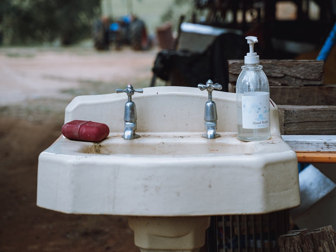 A white sink sitting next to a wooden table