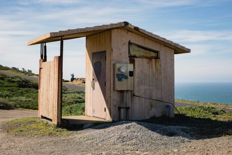 A small outhouse sitting on the side of a road