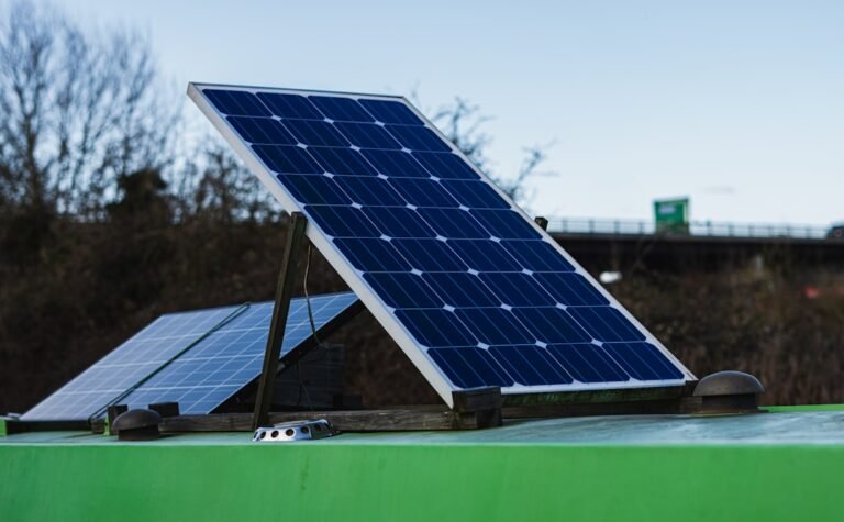 Blue and white solar panel on green metal bar during daytime
