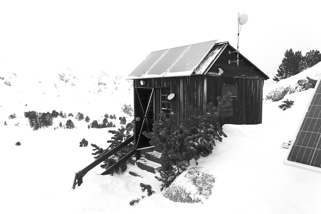 Wooden cabin with solar panels in snowy landscape
