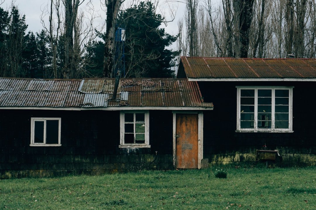 A black house with a rusted metal roof