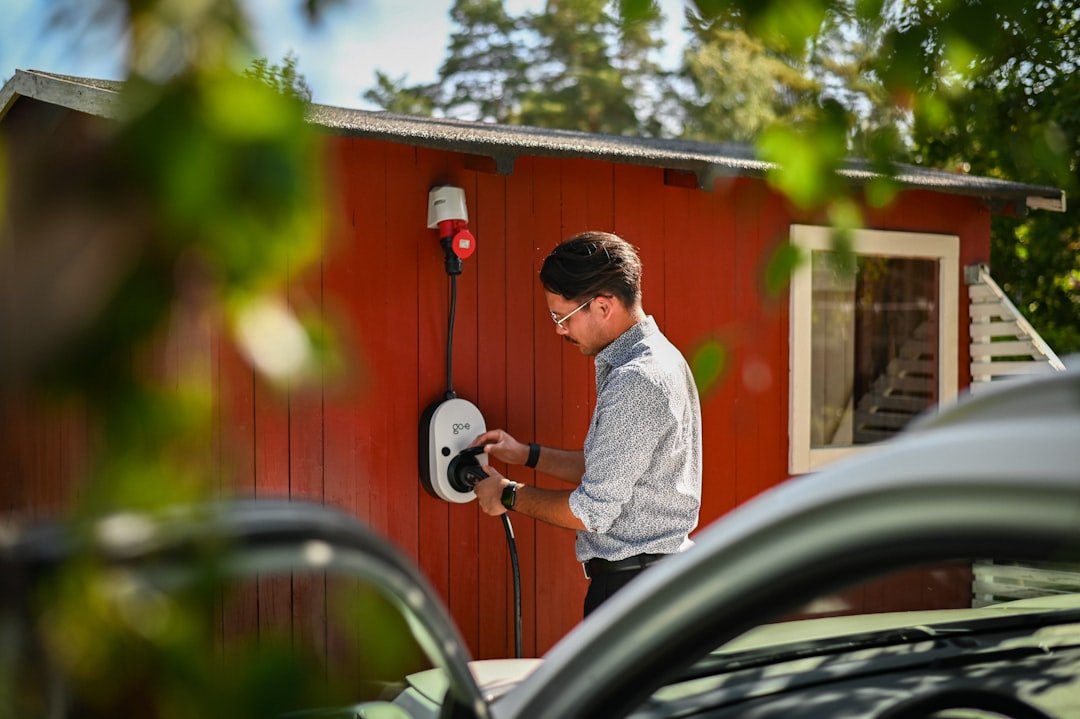 Man plugging in an electric car charger.