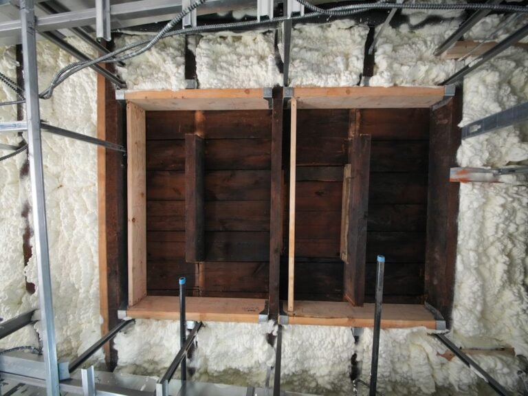 Wooden wall section with spray foam insulation.