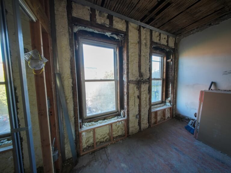 Room under construction with exposed insulation and windows
