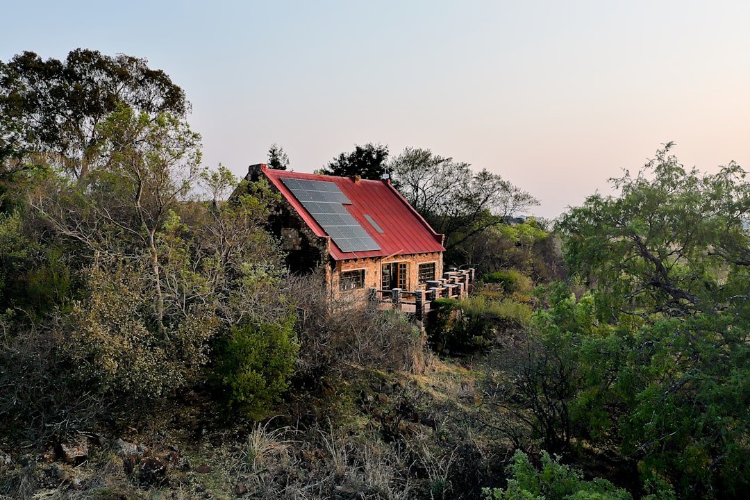 Small house with solar panels on a hill.