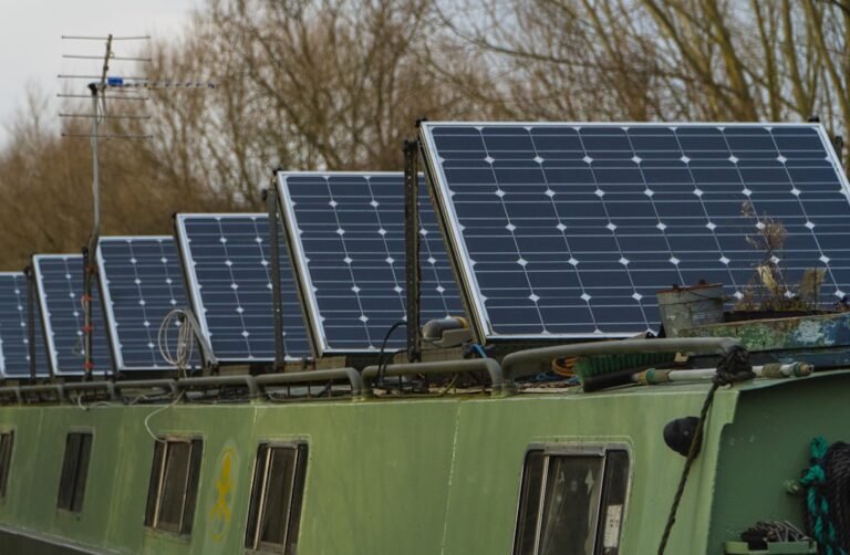 Blue solar panels on green and white bus